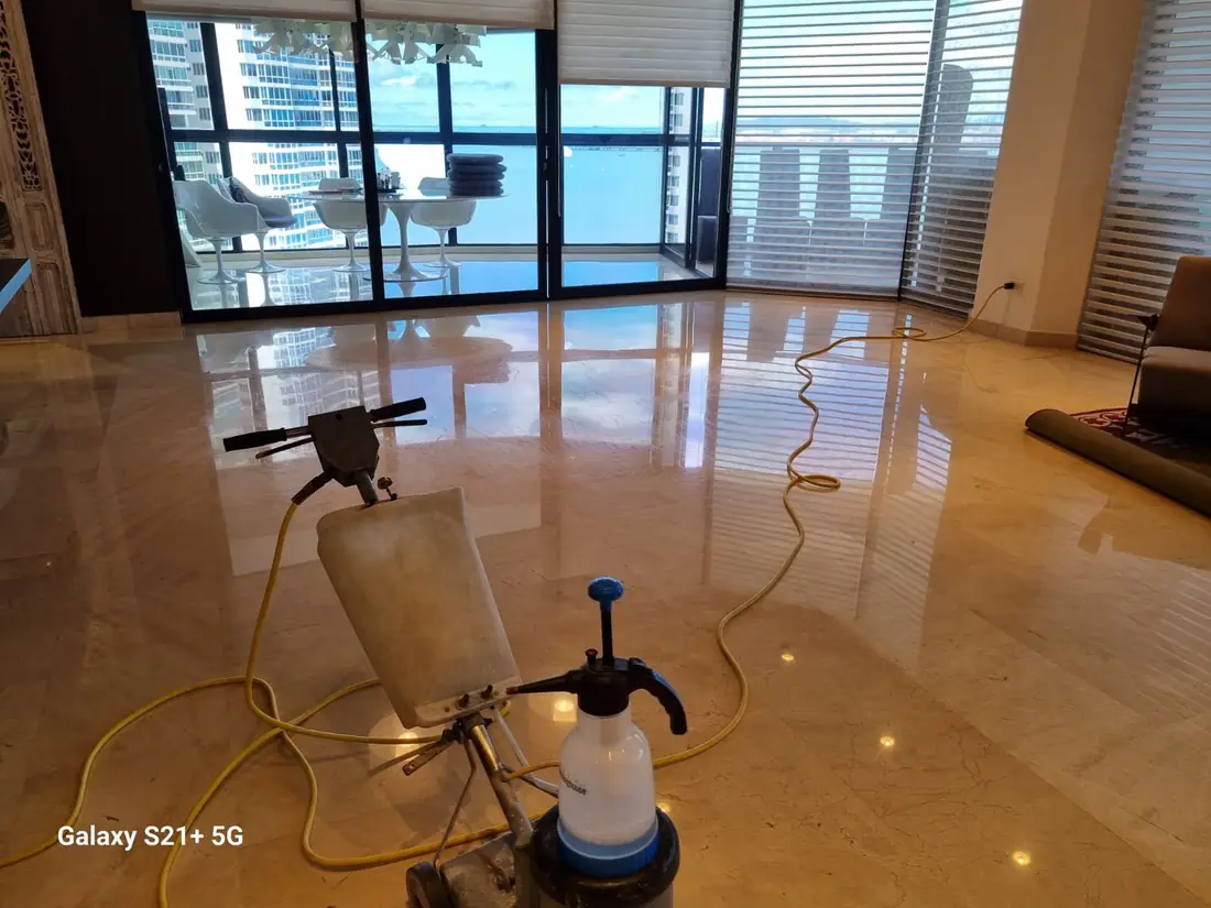 Operario con pulidora sobre mármol, vista al jardín